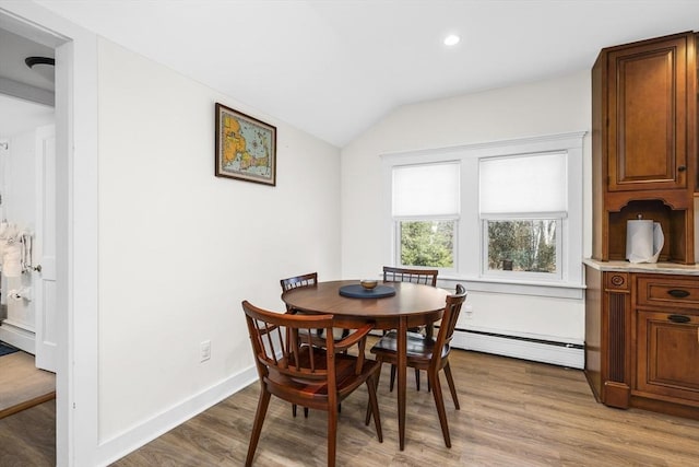 dining space with recessed lighting, baseboards, vaulted ceiling, baseboard heating, and light wood finished floors