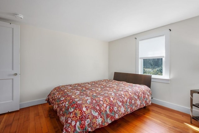 bedroom with baseboards and hardwood / wood-style floors