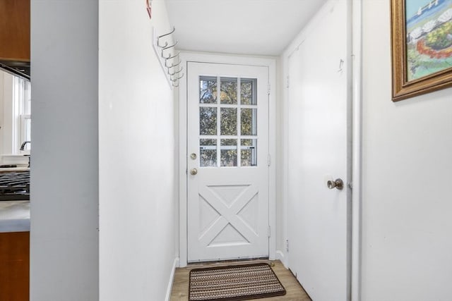 doorway with a sink and light wood-style floors