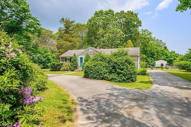 view of front of home featuring aphalt driveway and a front yard