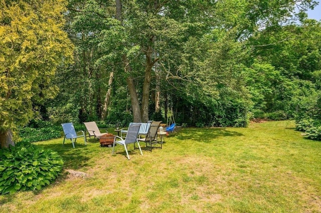 view of yard featuring a fire pit and a wooded view