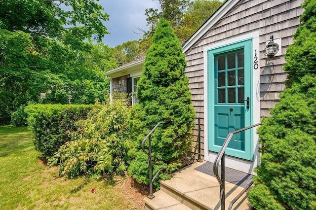 property entrance with a lawn