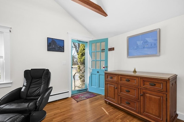 home office with a baseboard heating unit, lofted ceiling, and wood finished floors