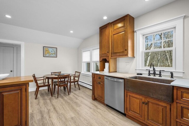 kitchen featuring light wood-style flooring, a sink, vaulted ceiling, brown cabinets, and dishwasher
