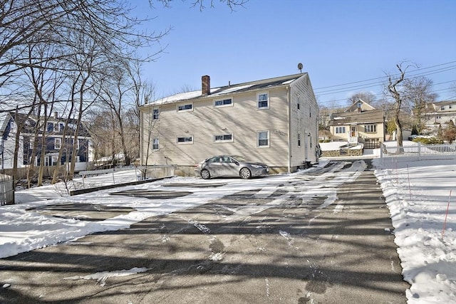 view of snow covered rear of property