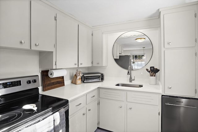 kitchen with appliances with stainless steel finishes, sink, and white cabinets