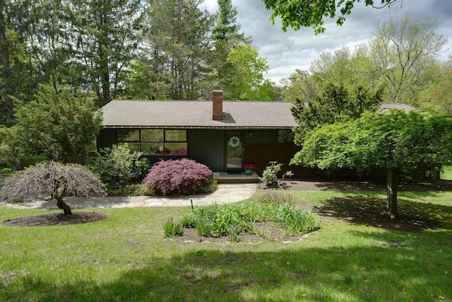 ranch-style house with a front lawn and a chimney