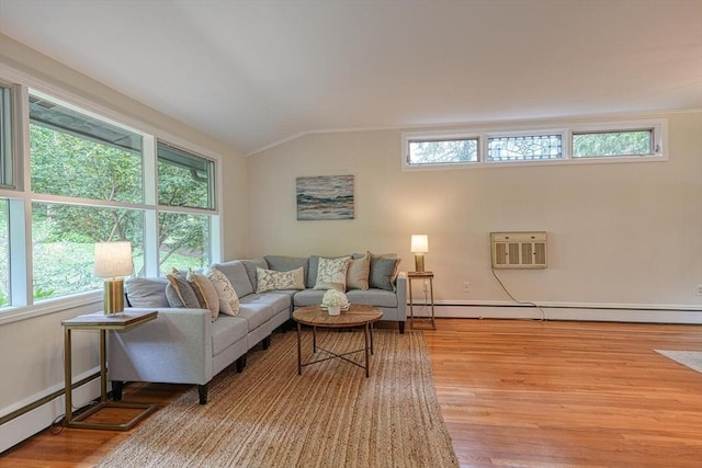 living room featuring baseboard heating, lofted ceiling, healthy amount of natural light, and wood finished floors