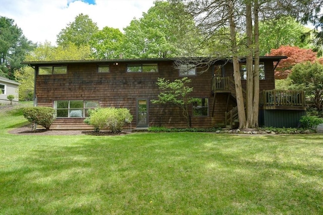 rear view of property with a lawn, stairway, and a deck