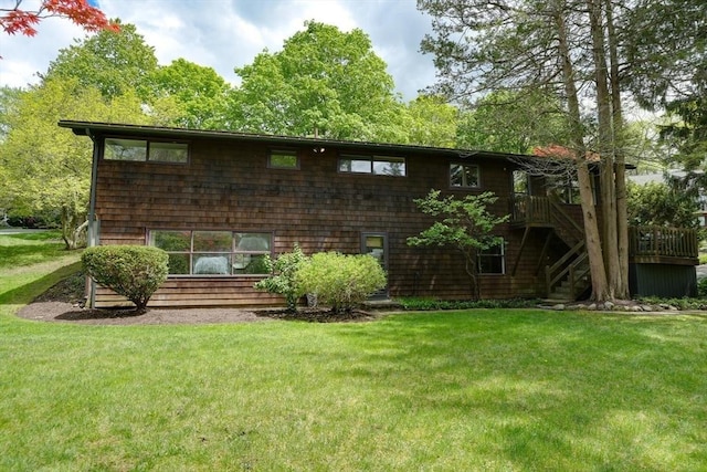 back of property featuring a yard, stairs, and a deck