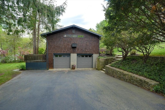 view of side of home featuring asphalt driveway