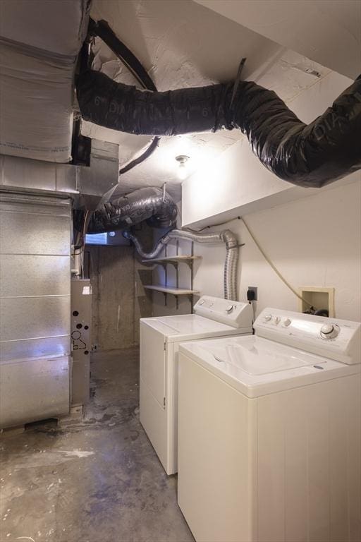 clothes washing area with washer and dryer and heating unit