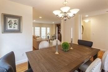 dining space featuring light wood-type flooring and a notable chandelier