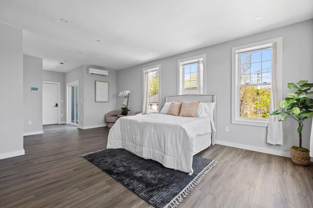 bedroom with baseboards, a wall mounted AC, and multiple windows