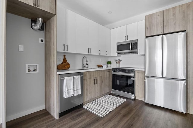 kitchen with decorative backsplash, dark wood-type flooring, light countertops, a sink, and appliances with stainless steel finishes