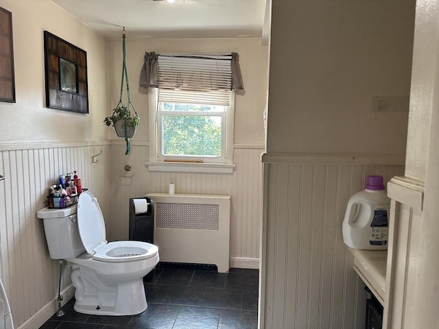 bathroom with radiator, wainscoting, toilet, and tile patterned flooring