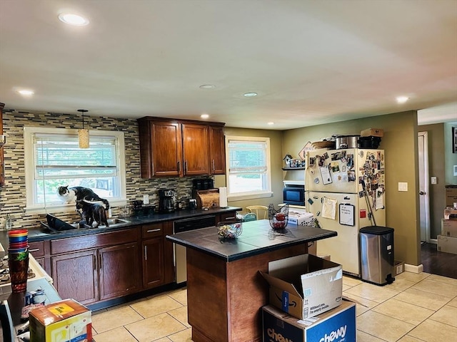 kitchen featuring freestanding refrigerator, dark countertops, light tile patterned floors, stainless steel dishwasher, and recessed lighting