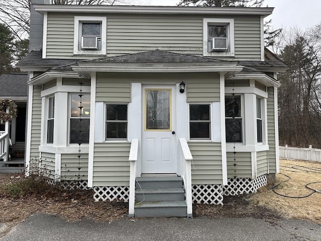 view of front facade featuring a shingled roof and entry steps