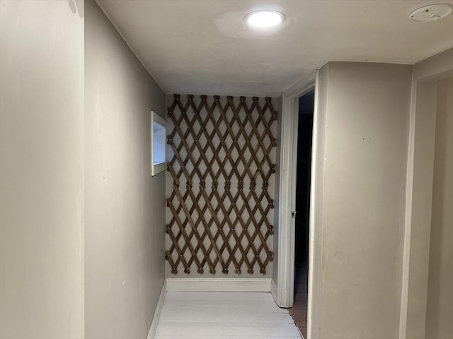 corridor featuring baseboards and light wood-style floors