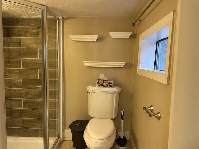 full bath featuring toilet, baseboards, and a shower stall