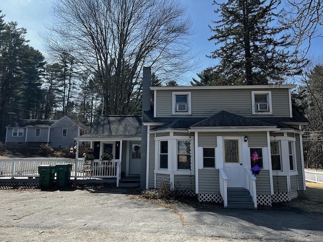 view of front of property featuring a shingled roof, cooling unit, entry steps, and a porch