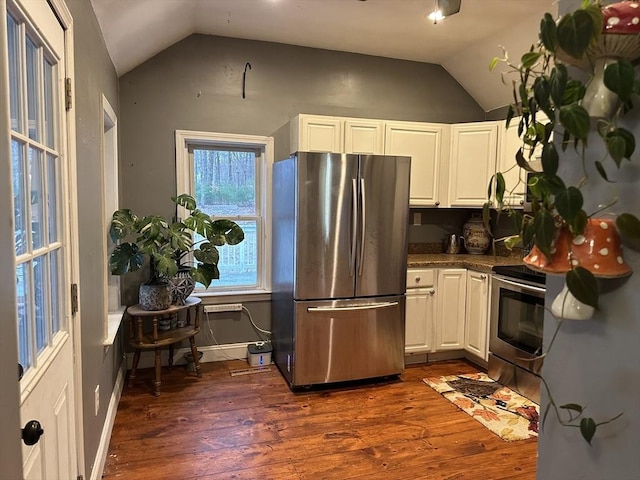 kitchen with appliances with stainless steel finishes, lofted ceiling, baseboards, white cabinets, and dark wood-style flooring