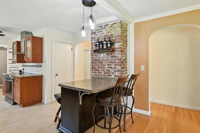 683 Rogers Ave, West Springfield, MA 01089 - kitchen featuring arched walkways, electric stove, brown cabinets, light wood-type flooring, and a kitchen bar