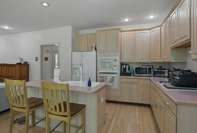 7 Alder Way Unit 7, Bedford, MA 01730 - kitchen with white appliances, light brown cabinetry, light wood-style flooring, a breakfast bar area, and a center island