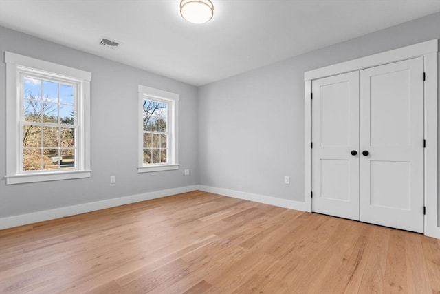 unfurnished bedroom with a closet and light hardwood / wood-style flooring