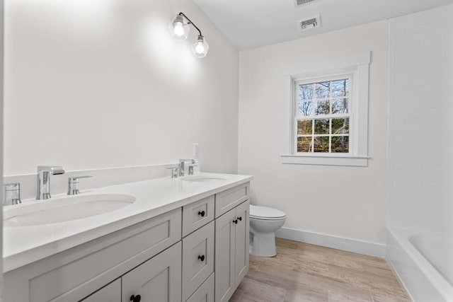 bathroom featuring hardwood / wood-style floors, vanity, and toilet