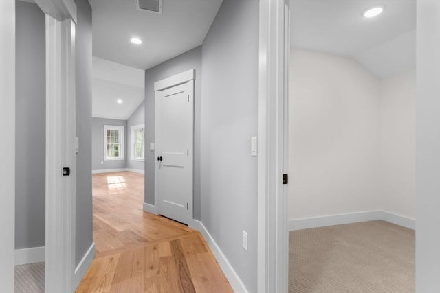 hall with light hardwood / wood-style flooring and vaulted ceiling