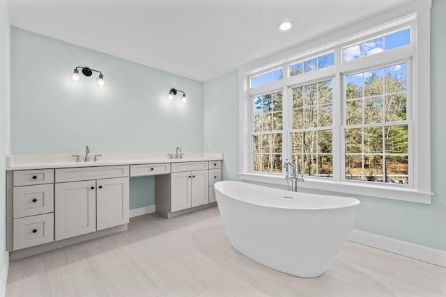 bathroom with a bathing tub, tile patterned flooring, and vanity