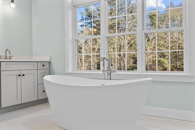 bathroom featuring vanity, a healthy amount of sunlight, and a tub