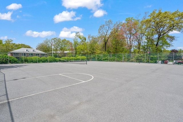 view of basketball court with fence and a tennis court