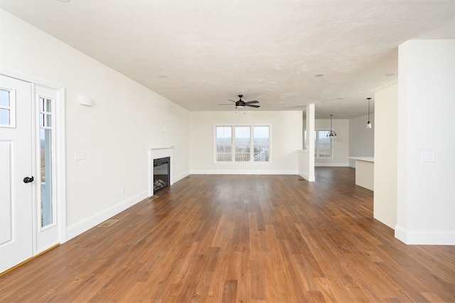 unfurnished living room with ceiling fan and dark hardwood / wood-style flooring