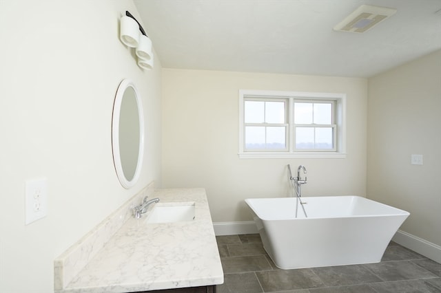 bathroom featuring vanity, a washtub, and tile patterned floors