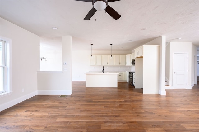 unfurnished living room featuring ceiling fan and dark hardwood / wood-style flooring