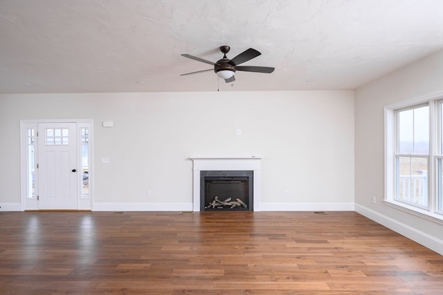 unfurnished living room featuring ceiling fan and hardwood / wood-style floors