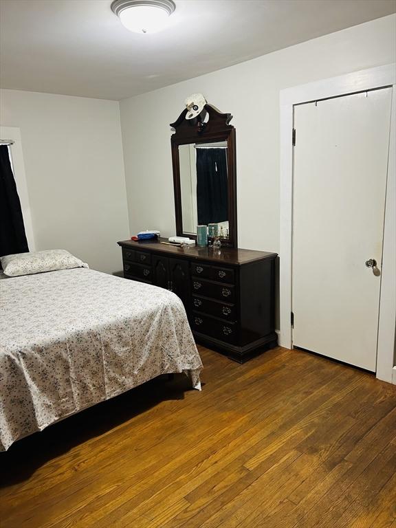 bedroom with dark wood-type flooring