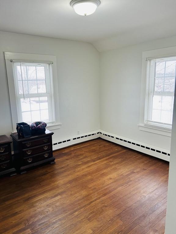 spare room featuring dark hardwood / wood-style floors and lofted ceiling