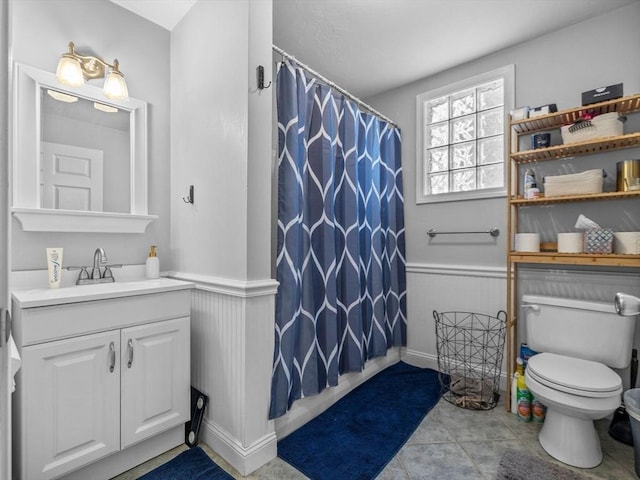 full bath with vanity, toilet, a wainscoted wall, and curtained shower
