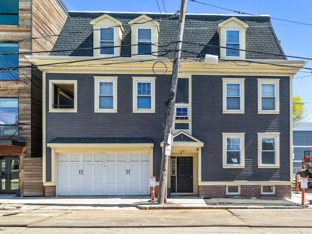 view of front of home featuring an attached garage, french doors, roof with shingles, and concrete driveway