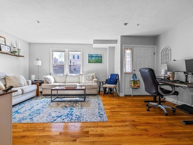 living area with baseboards and wood finished floors