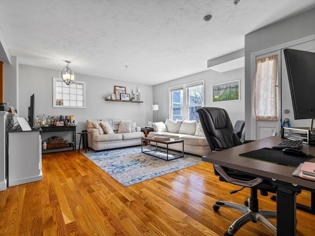 office space featuring light wood-style flooring and an inviting chandelier