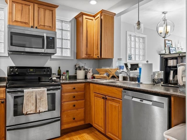 kitchen with brown cabinetry, dark countertops, and appliances with stainless steel finishes