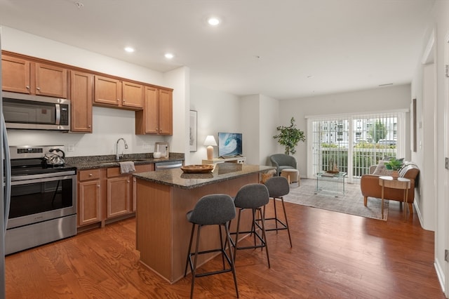 kitchen featuring a kitchen island, dark hardwood / wood-style floors, sink, and stainless steel appliances