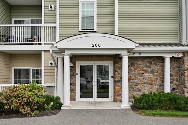 property entrance featuring a balcony and french doors