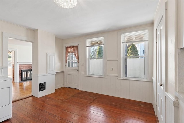 301 S Main, Haverhill, MA 01835 - entrance foyer featuring washer / clothes dryer, a fireplace, hardwood / wood-style floors, and a notable chandelier