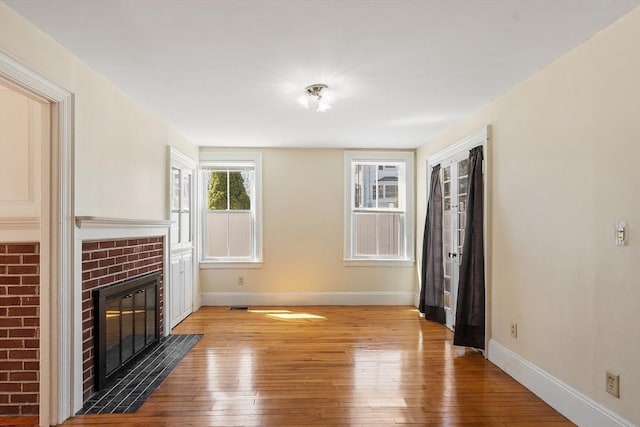 301 S Main, Haverhill, MA 01835 - unfurnished living room featuring baseboards, light wood-style flooring, and a tiled fireplace
