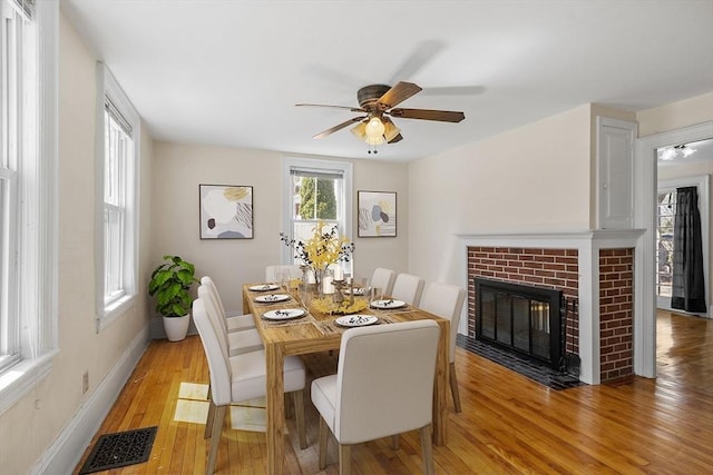 301 S Main, Haverhill, MA 01835 - dining space featuring ceiling fan, a fireplace, light wood-style floors, baseboards, and visible vents